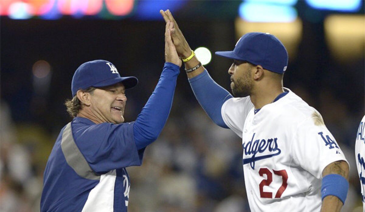 Don Mattingly, left, gives Matt Kemp a high-five after the Dodgers center fielder make a catch to save the game, giving L.A. a 6-5 victory over the San Francisco Giants.
