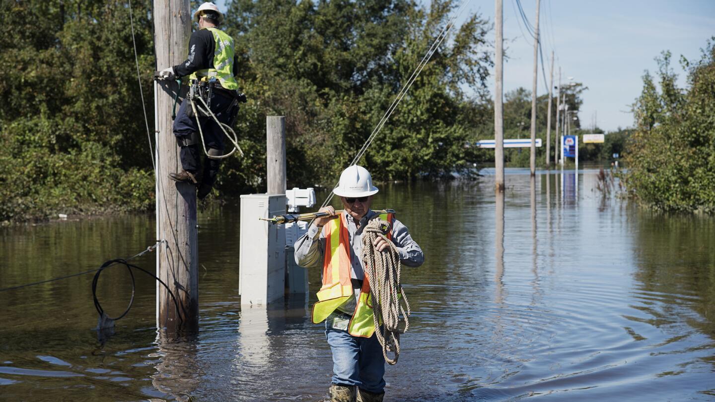 A lineman works to restore power lines near I-95 after the area was flooded by rain from Hurricane Matthew in Lumberton, N.C., on Oct. 11, 2016.