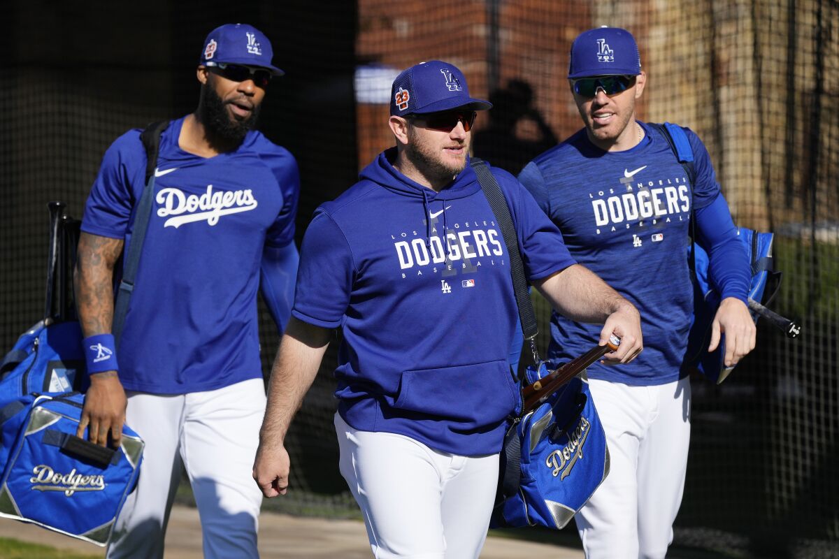 Dodgers teammates (from left) Jason Heyward, Max Muncy and Freddie Freeman walk with their gear.