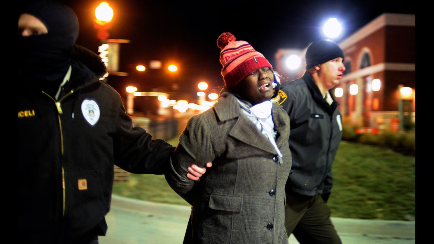 A protester is arrested and taken away by officers outside the Ferguson police station on Nov. 20.
