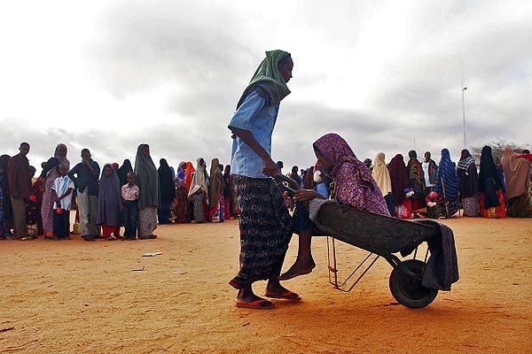 Ailing Batola Khalil Mohamed, 55, of Somalia is wheeled into the refugee camp in Dadaab, Kenya. Many refugees of late are fleeing drought, not war.