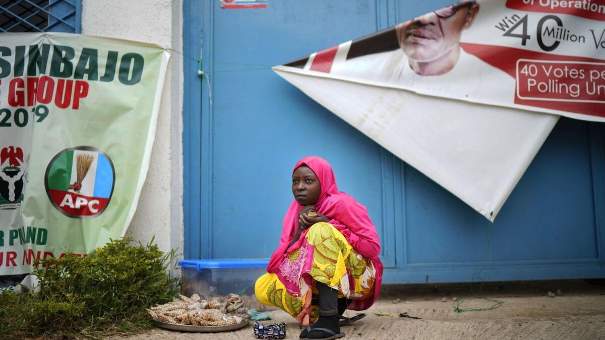 A woman sells peanuts outside President Muhammadu Buhari's campaign headquarters in Abuja, Nigeria, on Feb, 26, 2019.