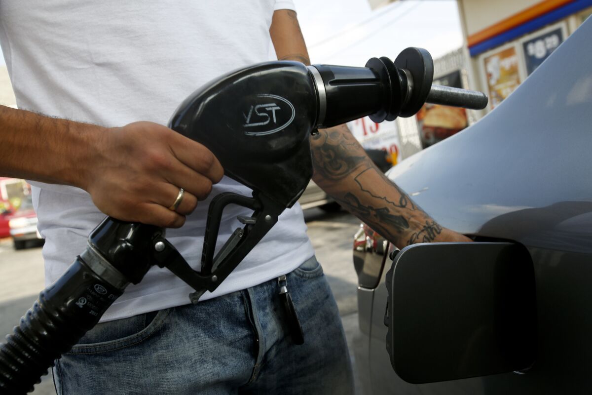 A customer fills up his car's gas tank at an Arco station on Whittier Boulevard in Los Angeles on Nov. 14, 2014.
