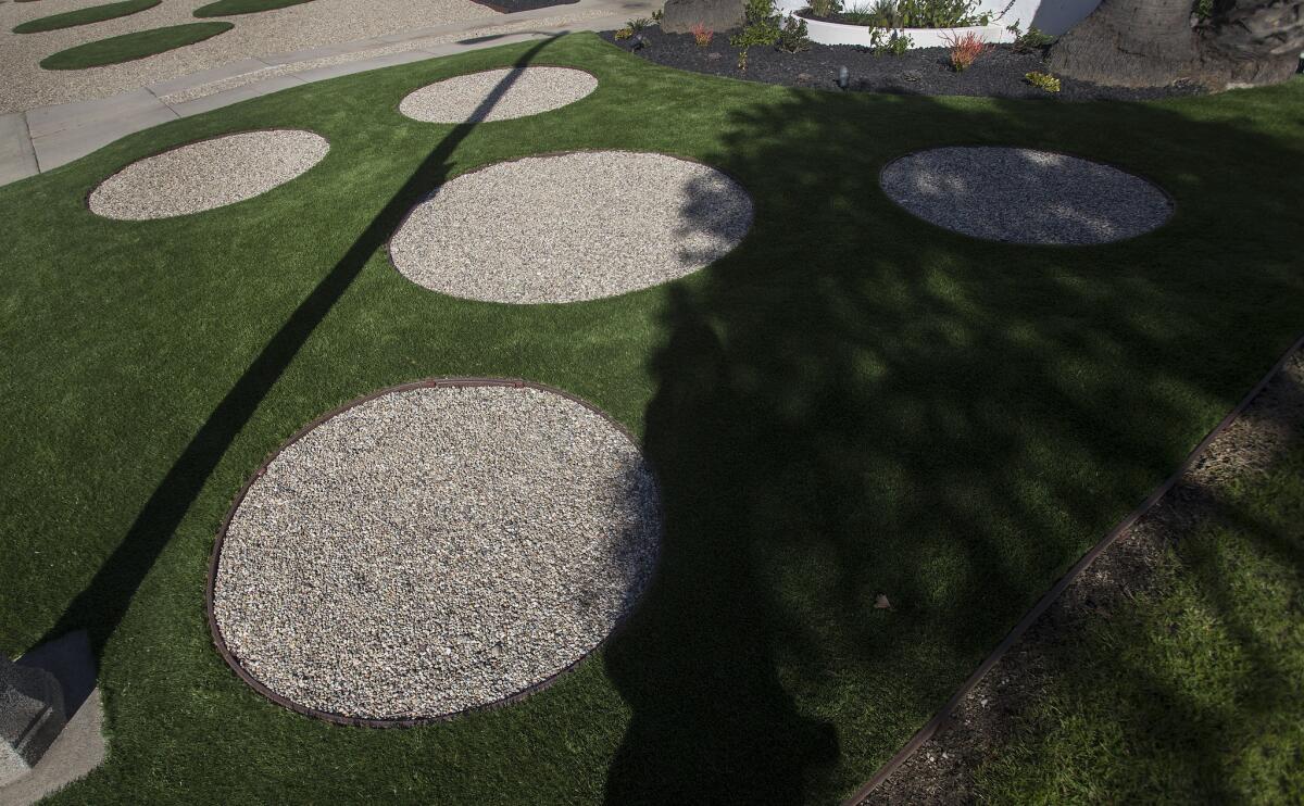 Circles of rock and artificial grass in front of a 1930s vintage home.
