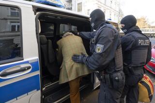 FILE - Masked police officers lead the arrested suspect Heinrich XIII Prince Reuss, left, to a police vehicle during a raid against so-called 'Reich citizens' in Frankfurt, Germany, Wednesday, Dec. 7, 2022. Germany’s federal prosecutor’s office says that criminal police have detained three more suspected far-right extremists who are linked to an alleged plot by the Reichsbuerger, or Reich Citizens, movement to topple the country’s government. (Boris Roessler/dpa via AP, File)