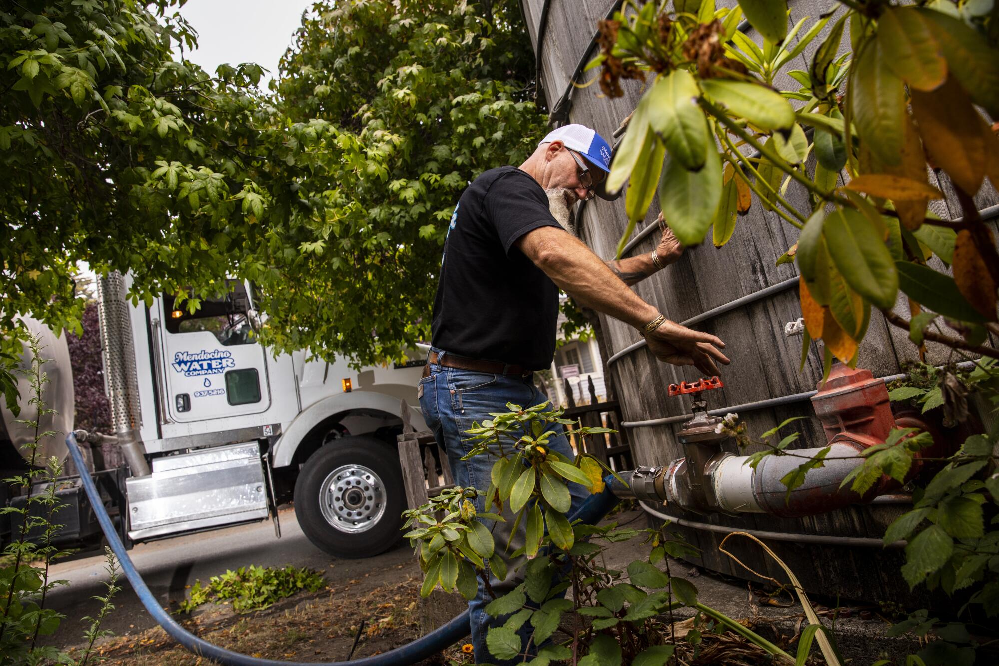 Wayne Jones connects his water truck to make a delivery in Mendocino.