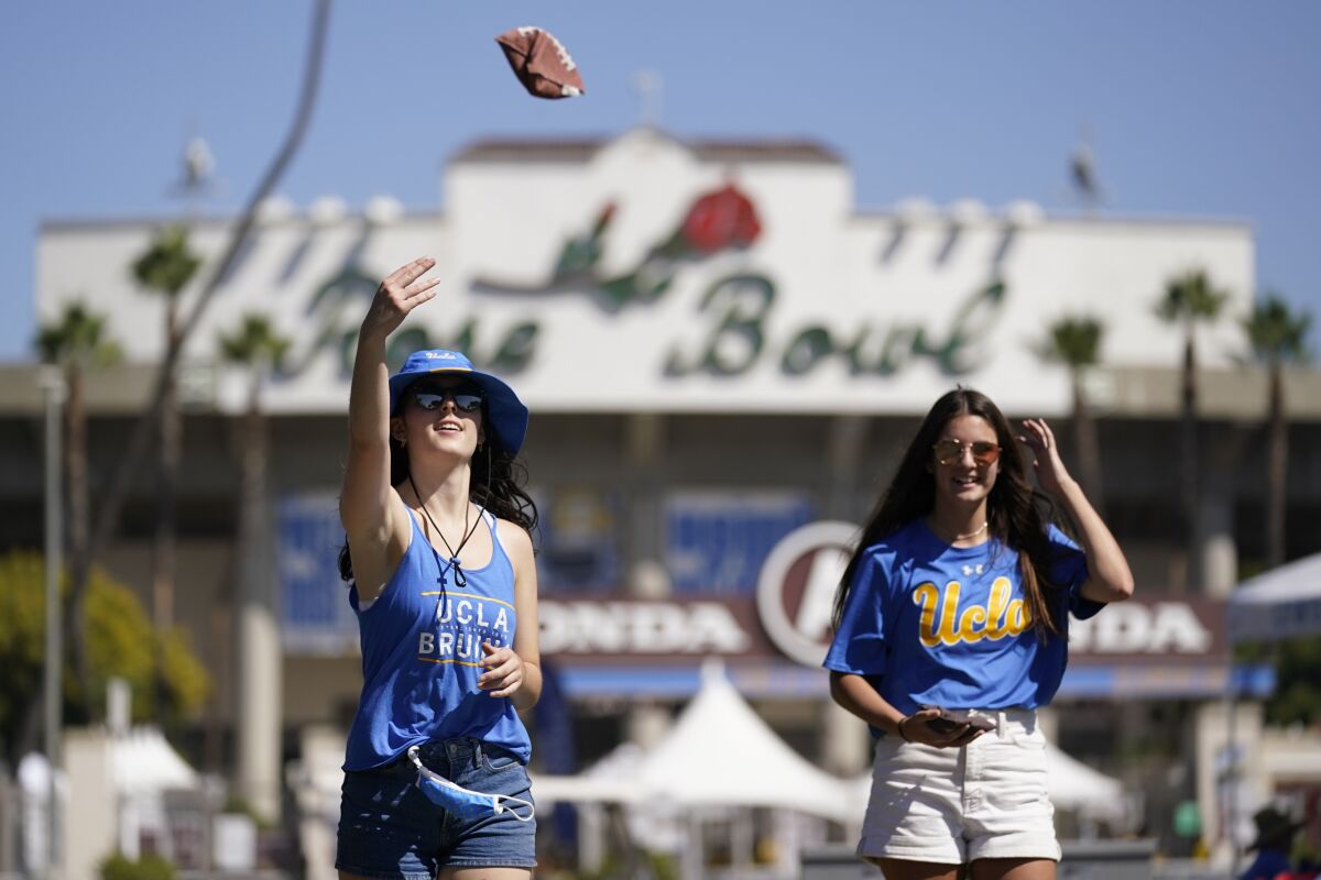 Gwyneth Schoenbaum, left, and Maddy Perdue play corn hole while tailgating outside of the Rose Bowl 