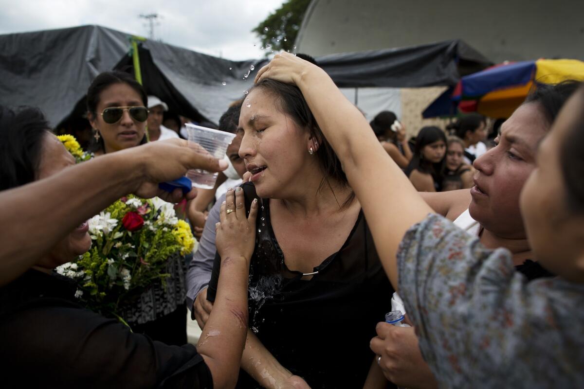 A mourner in Portoviejo is revived with splashes of water before family members head to a nearby cemetery to bury loved ones who were killed in the magnitude 7.8 earthquake in Ecuador.