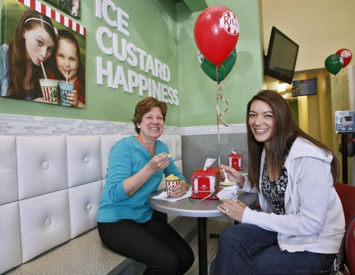 Judy Cosgrove of La Canada Flintridge, left, and her soon-to-be daughter-in-law Megan Dipane, right, enjoy a free regular Italian ice at the grand opening of Rita's.