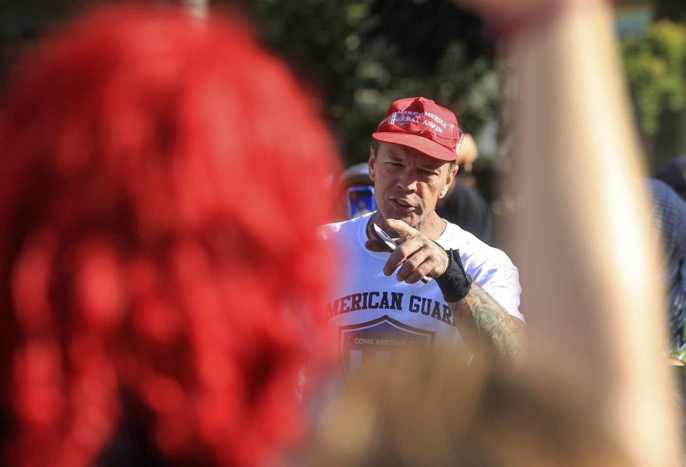 A man points toward supporters of the Drag Queen Story Hour while he stands with protesters against the story hour at the Chula Vista Public Library Civic Center Branch on Tuesday, September 10, 2019 in Chula Vista, California.