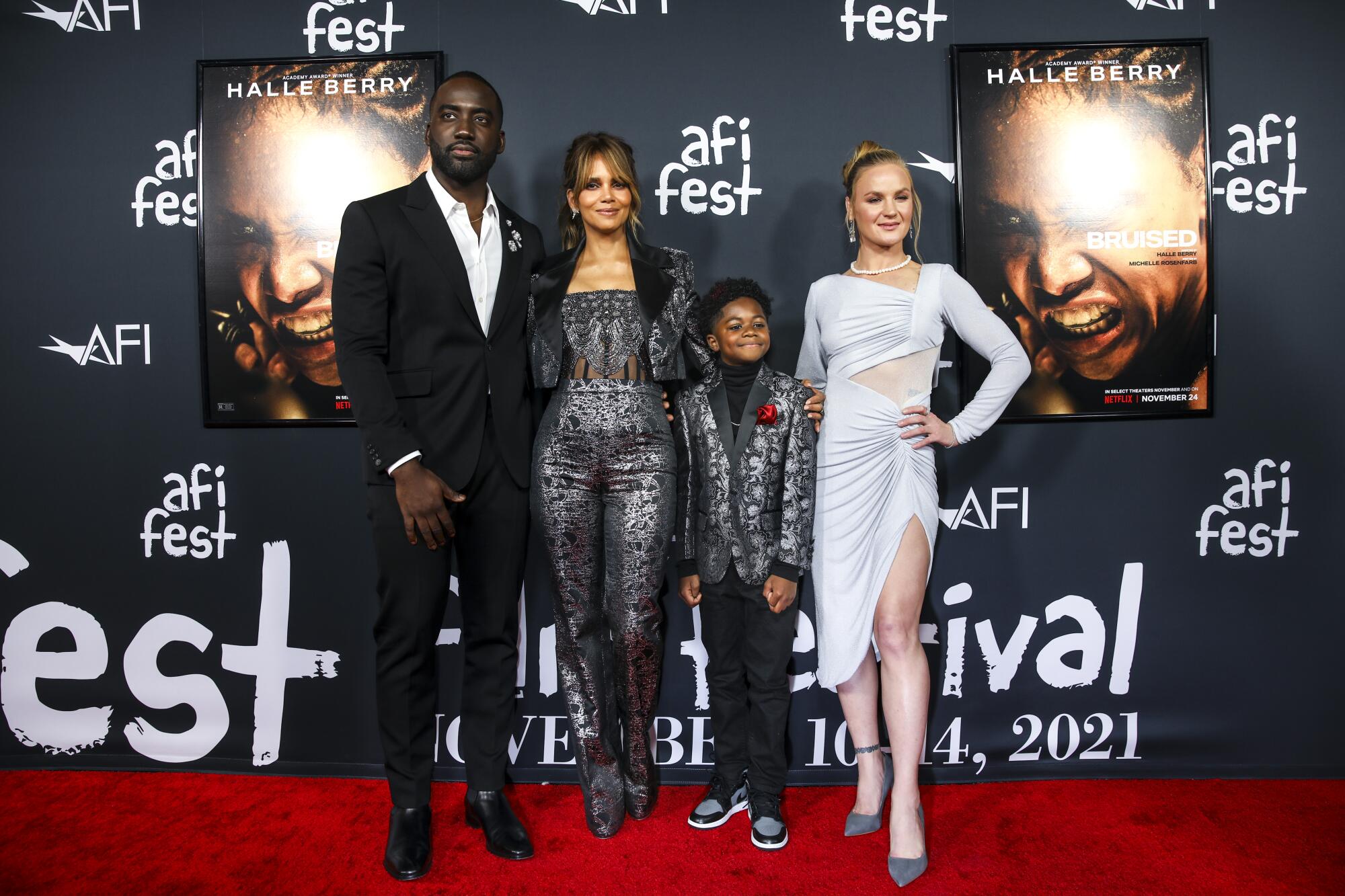 Shamier Anderson, Halle Berry, Danny Boyd Jr. and Valentina Shevchenko stand before a wall with AFI Fest logos and posters