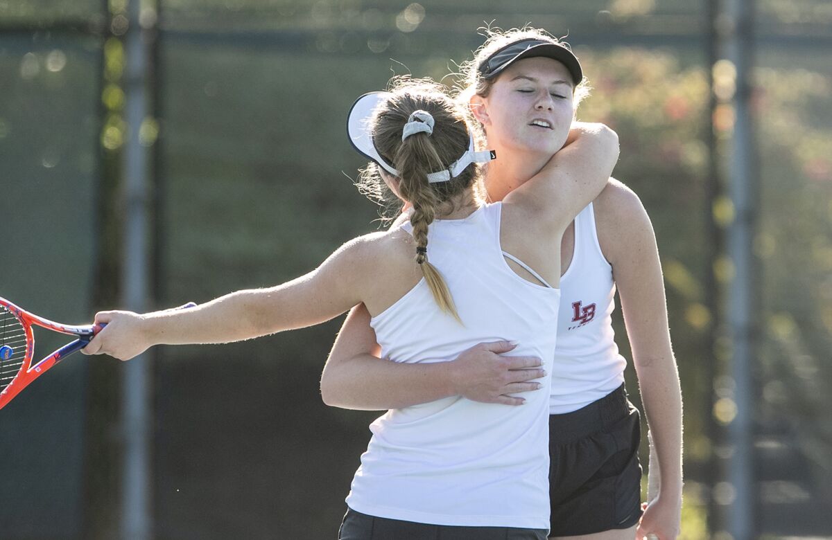 Laguna Beach's Sarah MacCallum, left, and Ella Pachl hug after winning the CIF Southern Section Individuals doubles title match against Beckman's Kiki Nguyen and Victoria Aguirre on Monday at Seal Beach Tennis Center.
