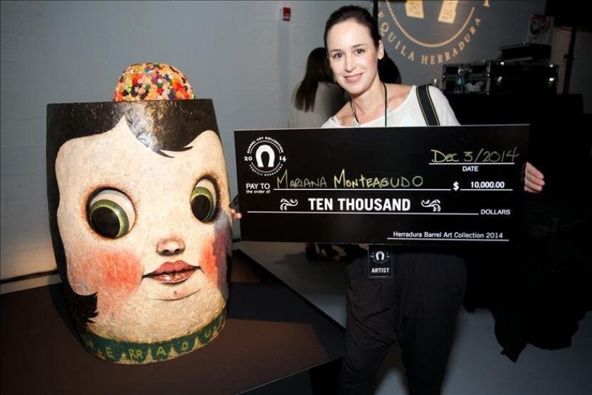 Venezuelan sculptor Mariana Monteagudo poses with the winning work she created for Tequila Herradura's Barrel Art Collection contest, which required competitors to make an art work out of a traditional oak barrel. EFE/Tequila Herradura