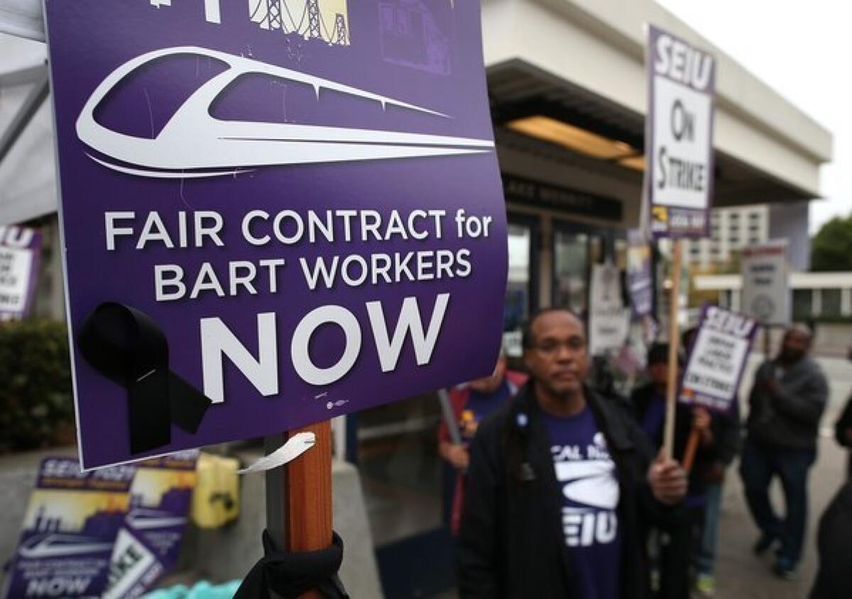 Striking BART workers picket in front of the Lake Merritt station on Monday.