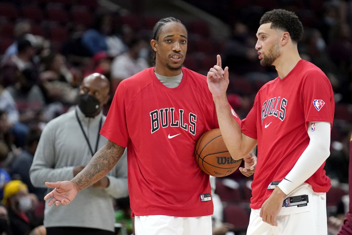 during the Chicago Bulls' DeMar DeRozan, left, and Zach LaVine talk during warm ups before the start of the second half of an NBA preseason basketball game against the Cleveland Cavaliers Tuesday, Oct. 5, 2021, in Chicago. (AP Photo/Charles Rex Arbogast)