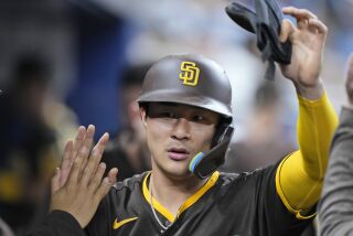 San Diego Padres' Ha-Seong Kim is congratulated by teammates after he scored on a single by Juan Soto during the fifth inning of a baseball game against the Miami Marlins, Tuesday, May 30, 2023, in Miami. (AP Photo/Wilfredo Lee)