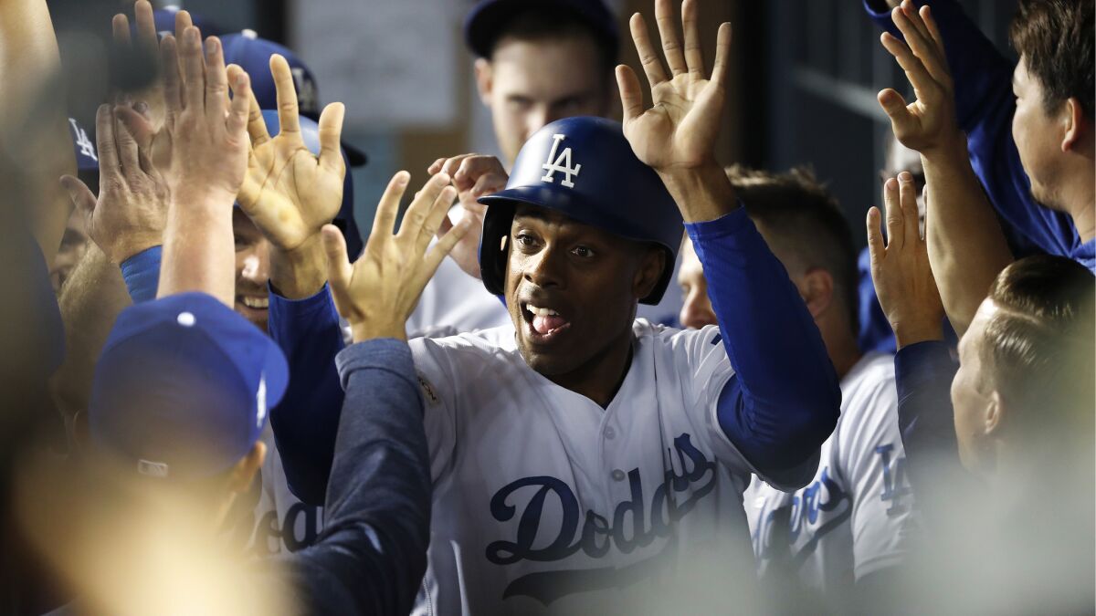 Curtis Granderson high-fives in the dugout after scoring on a 2-run double on a hit by Austin Barnes in the 5th inning.