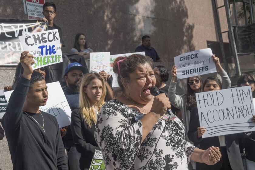 Los Angeles, CA - August 16, 2019 - Lisa Vargas, mother of Anthony Vargas who was shot and killed by sheriff's deputies in 2017, speaks in front of the Stanley Mosk Courthouse on Friday. A rally was held before a hearing on a lawsuit against Sheriff Alex Villanueva for reinstating a deputy previously fired for domestic violence. Various groups called for more checks and balances on the sheriff's department. Ken Mendoza and actor Jessica Barth stand at left (Ana Venegas / For The Times))