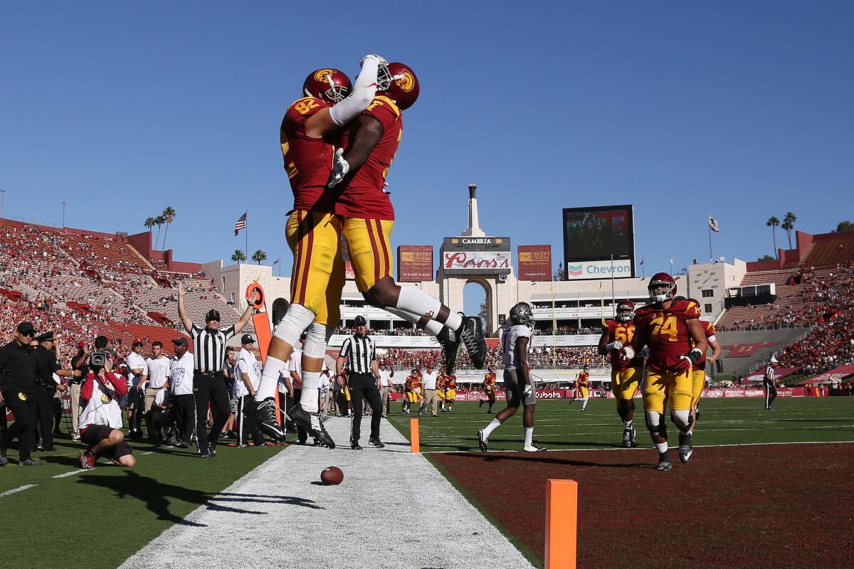 USC tight end Tyler Petite (82) is congratulated by wide receiver Darreus Rogers (1) after scoring the go-ahead touchdown against Colorado in the fourth quarter at the Coliseum on Oct. 8.