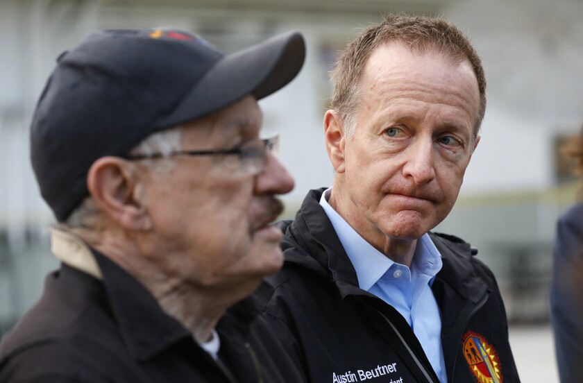 Two men stand next to each other.