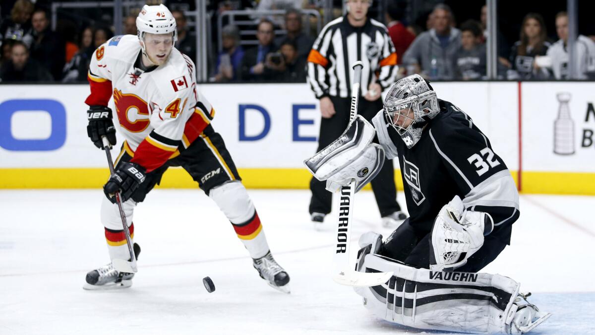 Kings goalie Jonathan Quick makes a save in front of Flames center Hunter Shinkaruk during a game March 31.