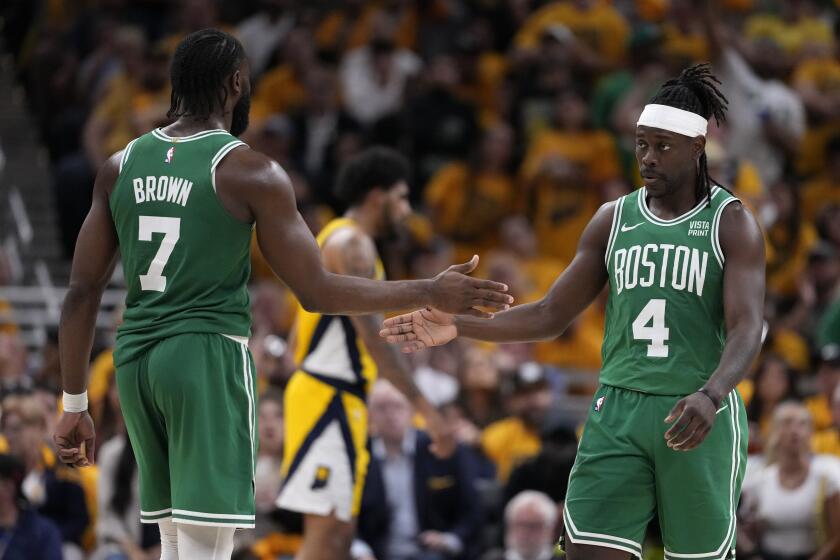 Boston Celtics guard Jrue Holiday (4) celebrates with teammate guard Jaylen Brown.