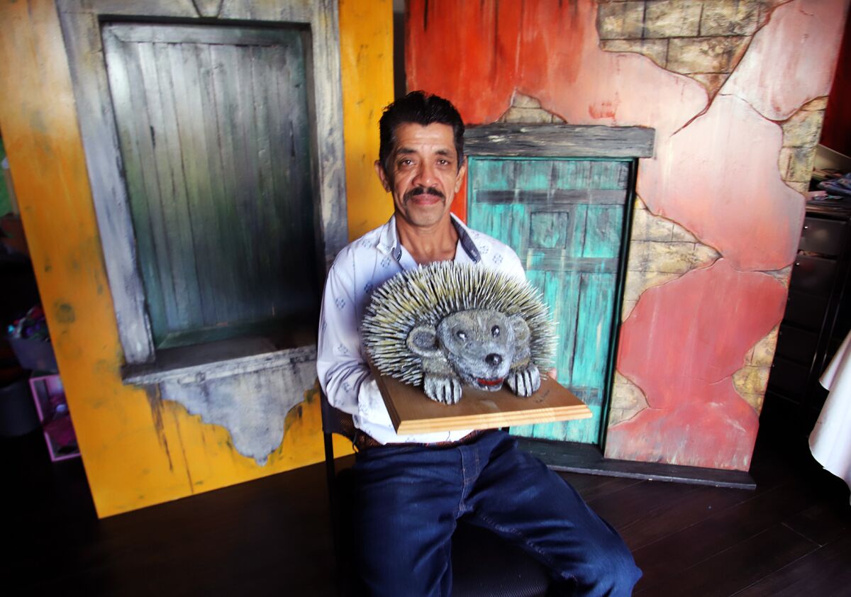 Artist Raul Monterroso, of San Fernando, holds a porcupine that he carved from recycled wood.