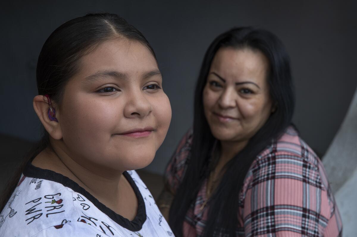 A smiling mother and daughter.