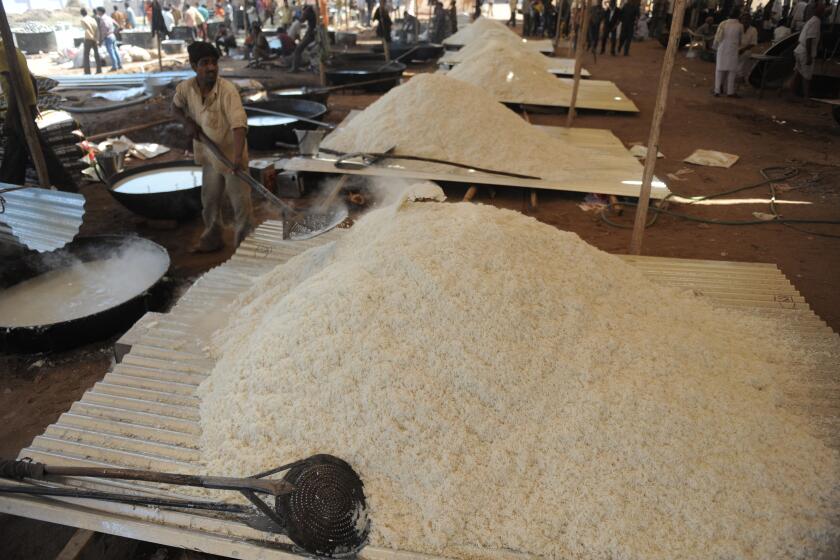 Indian cooks prepare basmati rice during the Brahma Chorayasi festival in Ahmedabad on February 26, 2012. This is the first time in 97 years that Ahmedabad is playing host to the religious event. AFP PHOTO / Sam PANTHAKY (Photo credit should read SAM PANTHAKY/AFP via Getty Images)