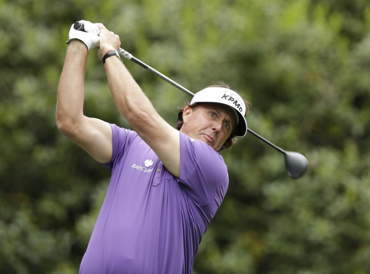 Phil Mickelson watches his tee shot on the 14th hole on Friday.