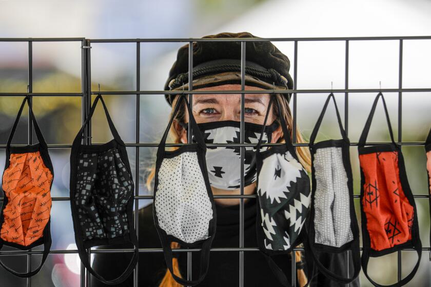 VENICE, CA - APRIL 18: Alisun Franson sells face masks from a stand in front of her business Amiga Wild in Venice. Venice, CA. (Irfan Khan / Los Angeles Times)