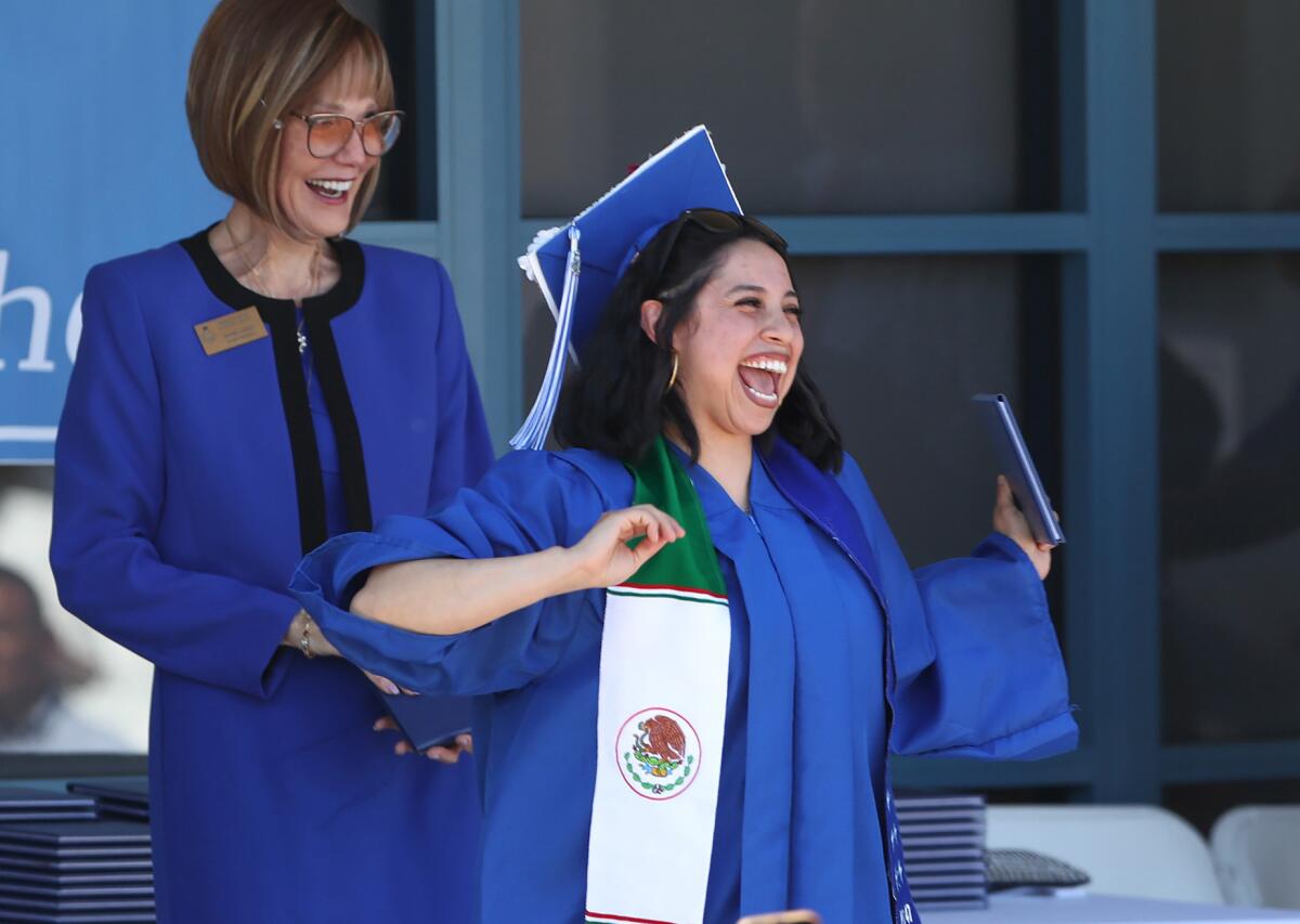 Bethzy Garcia is all smiles as she receives her diploma from Diana Carey of the district's board of trustees.
