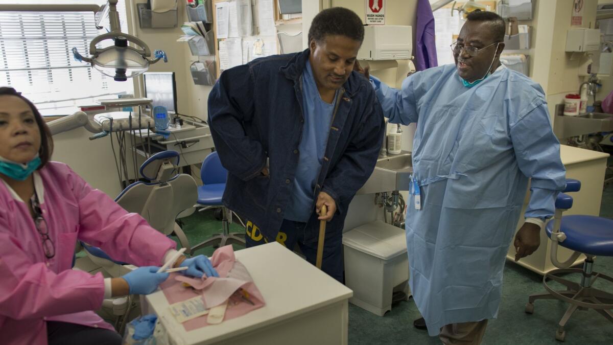 Dentist Opanin Gyaami treats inmate and patient Larry Butler in 2012 at the California medical facility in Vacaville.