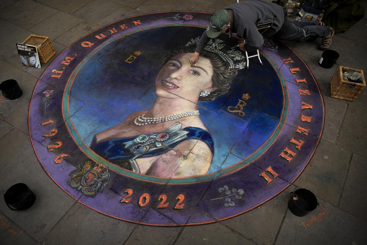 Pavement chalk artist Julian Beever applies finishing touches to an artwork depicting Queen Elizabeth II in Central London, Thursday, Sept. 15, 2022. The Queen will lie in state in Westminster Hall for four full days before her funeral on Monday Sept. 19. (AP Photo/Andreea Alexandru)