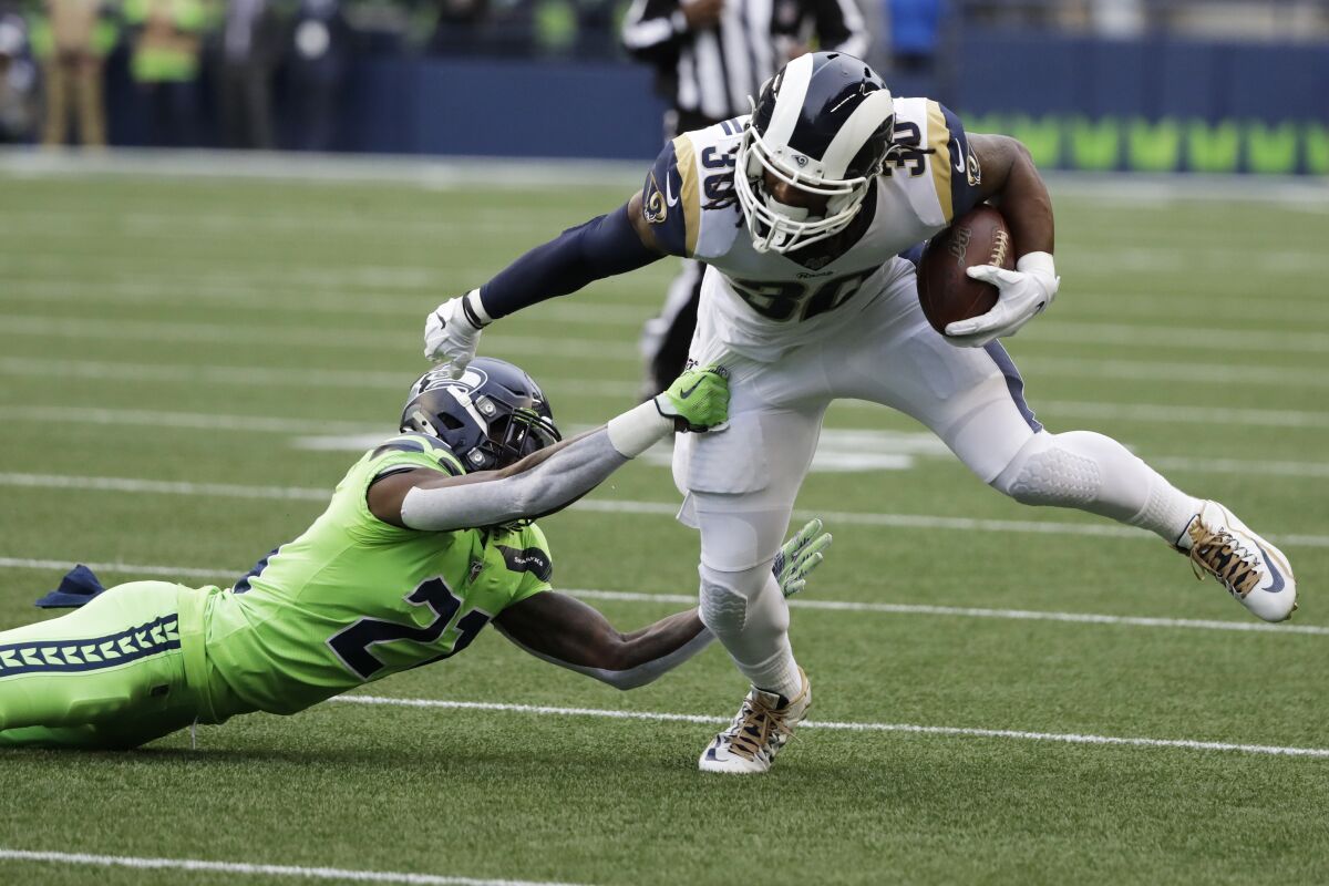 Rams running back Todd Gurley tries to fend off Seahawks cornerback Tre Flowers on Oct. 3 in Seattle.