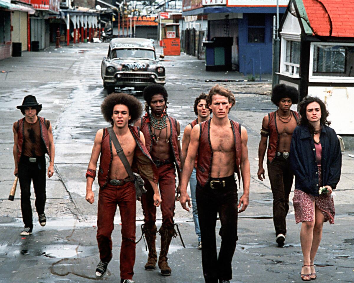 Shirtless gang members in vests walk the streets of New York in "The Warriors."