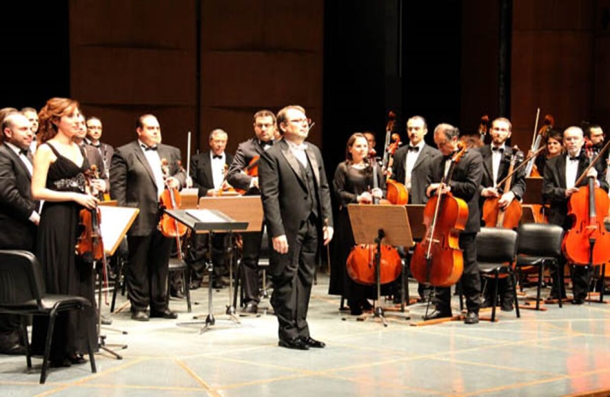 Violinist Rawan Al-Kurdi stands with orchestra 