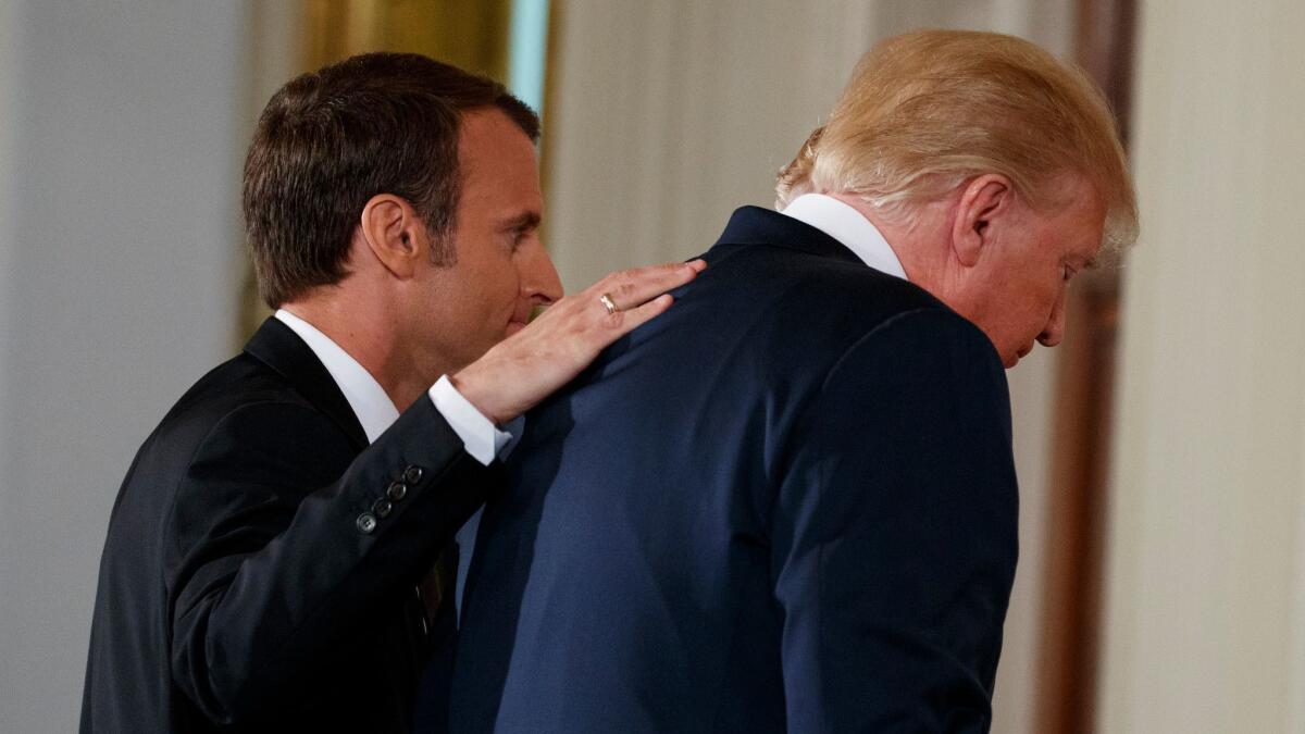French President Emmanuel Macron and President Trump walk off after a news conference at the White House.