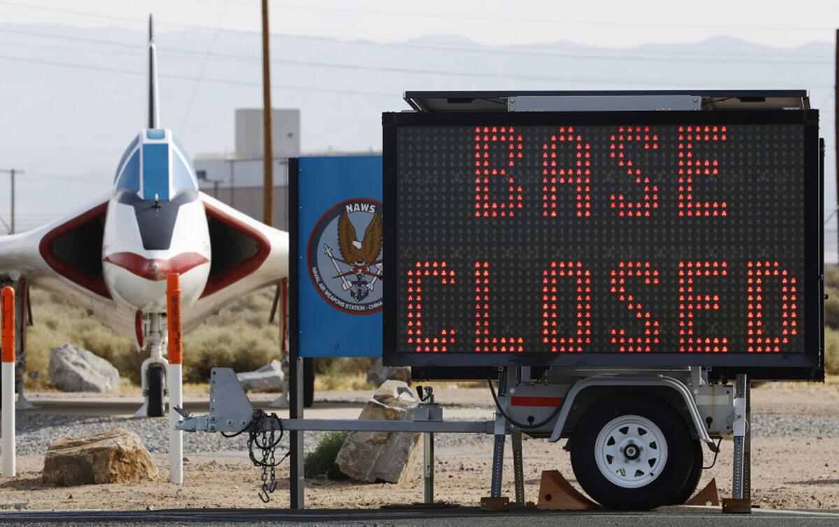A sign posted July 7 outside the main gate of the China Lake naval station in Ridgecrest, Calif., shows the base is closed.