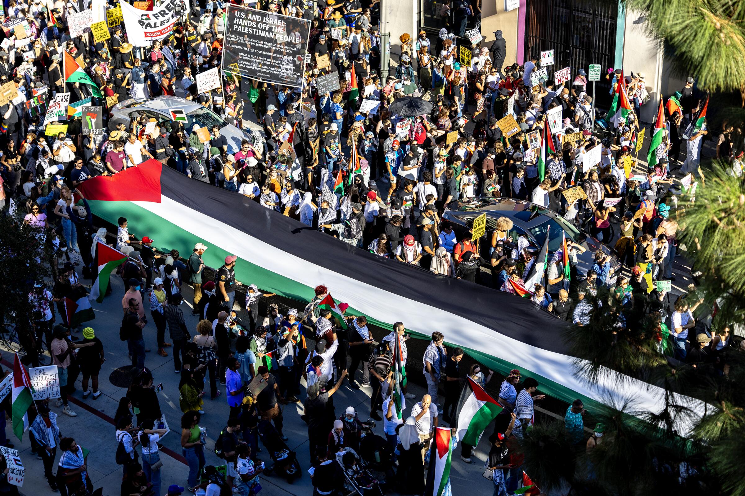  A large Palestinian flag is carried as thousands of demonstrators march in Los Angeles.