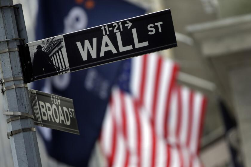 A Wall Street sign is seen next to the New York Stock Exchange in New York City.