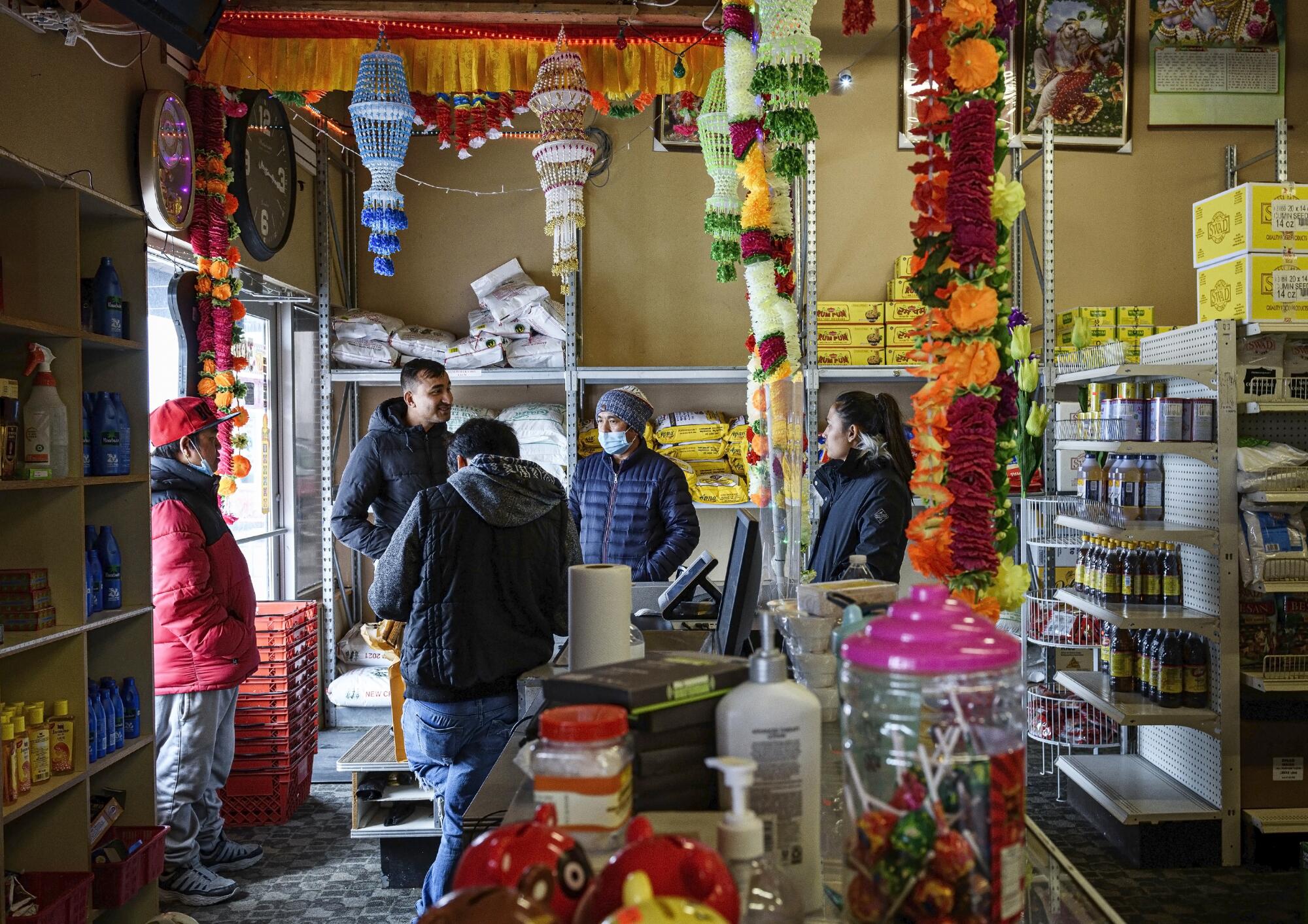 People stand at the end of a counter at a store.