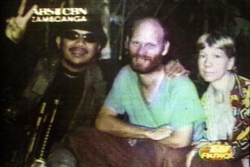 Kidnapped American missionaries Martin, center, and Gracia Burnham, right, who were kidnapped from a Philippines resort eight months ago, are seen beside their abductor Abu Sabaya, leader of the Muslim extremist group the Abu Sayyaf in this undated photo made from video, originally a still photo, released on Oct. 10, 2001. (ABS CBN via AP, file)