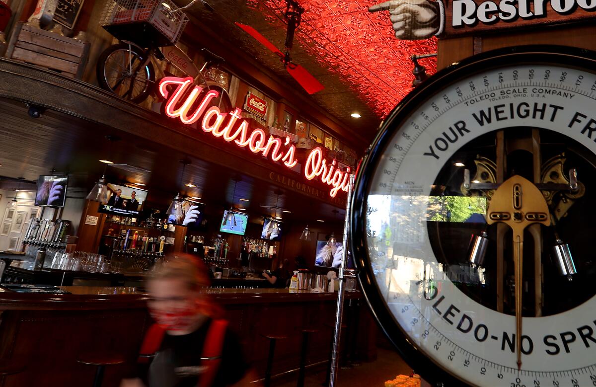 A server wears a protective mask at Watson's Original Soda Fountain in downtown Orange. 