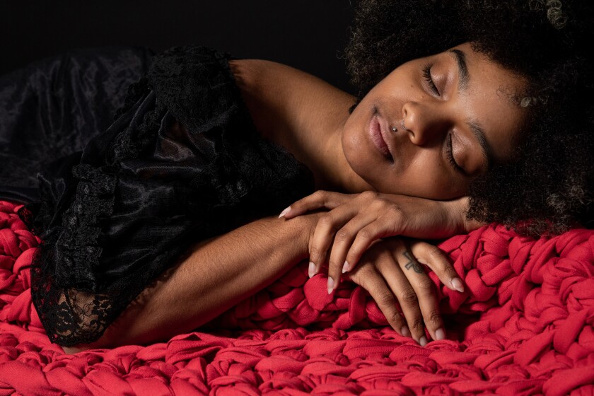 A photo of a model with a Sheltered Co. weighted blanket.