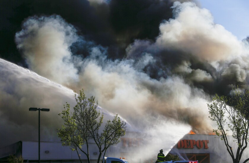 Firefighters work on a five-alarm fire at the Home Depot off Blossom Hill Road in San Jose, Calif., on Saturday, April 9, 2022. A shelter-in-place advisory was expected to remain in effect until at least early Sunday afternoon for residents living or working near the store that was destroyed Saturday in a fiery blaze. (Shae Hammond/Bay Area News Group via AP)