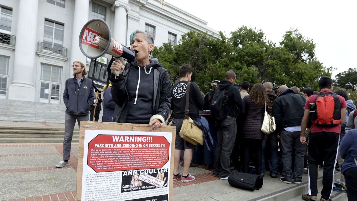 A protester uses a bullhorn to make her feelings known during a news conference held by the Berkeley College Republicans in Sproul Plaza on the UC Berkeley campus. The event was held to discuss last year's cancellation of speaker Ann Coulter's appearance on campus.
