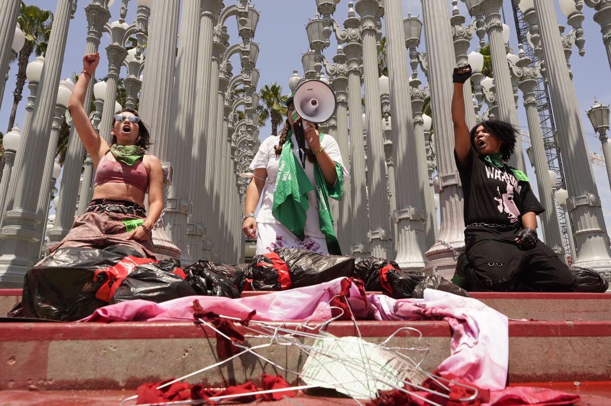 Abortion rights activists stage a 'die-in' protest by chaining themselves to the lamp post installation 'Urban Light.'