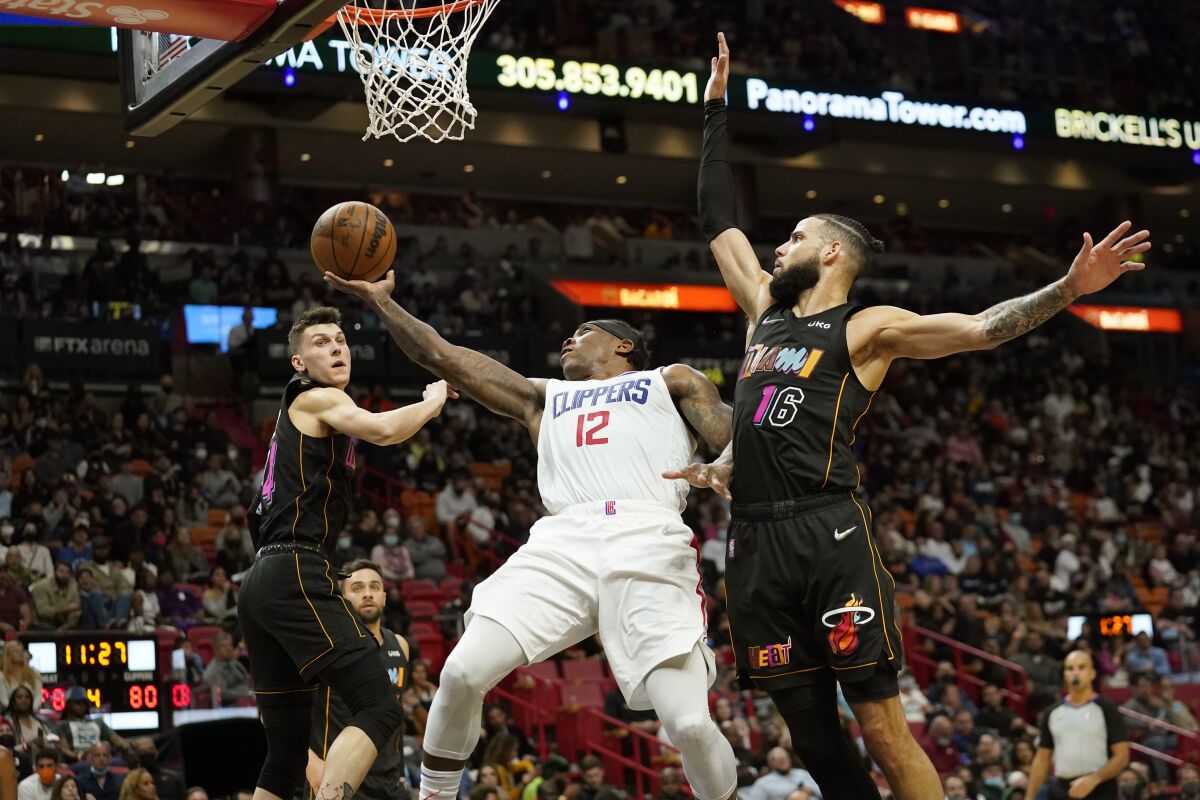 The Clippers' Eric Bledsoe goes up for a shot as the Heat's Tyler Herro, left, and Caleb Martin defend Jan. 28, 2022.
