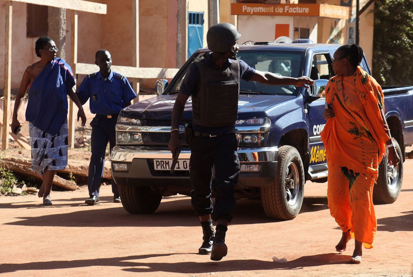 Malian security forces evacuate two women from an area surrounding the Radisson Blu hotel.